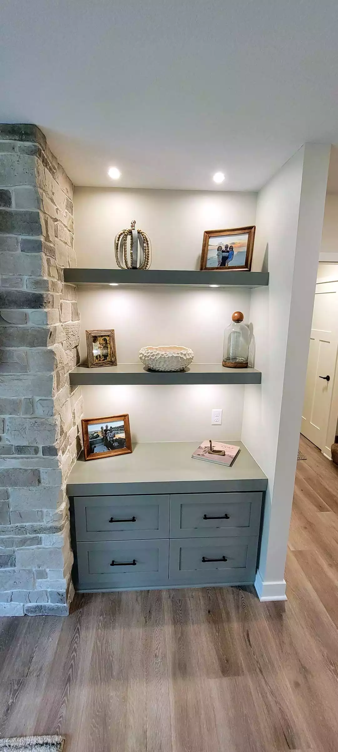 Floating shelves and cabinets flanking fireplace wall