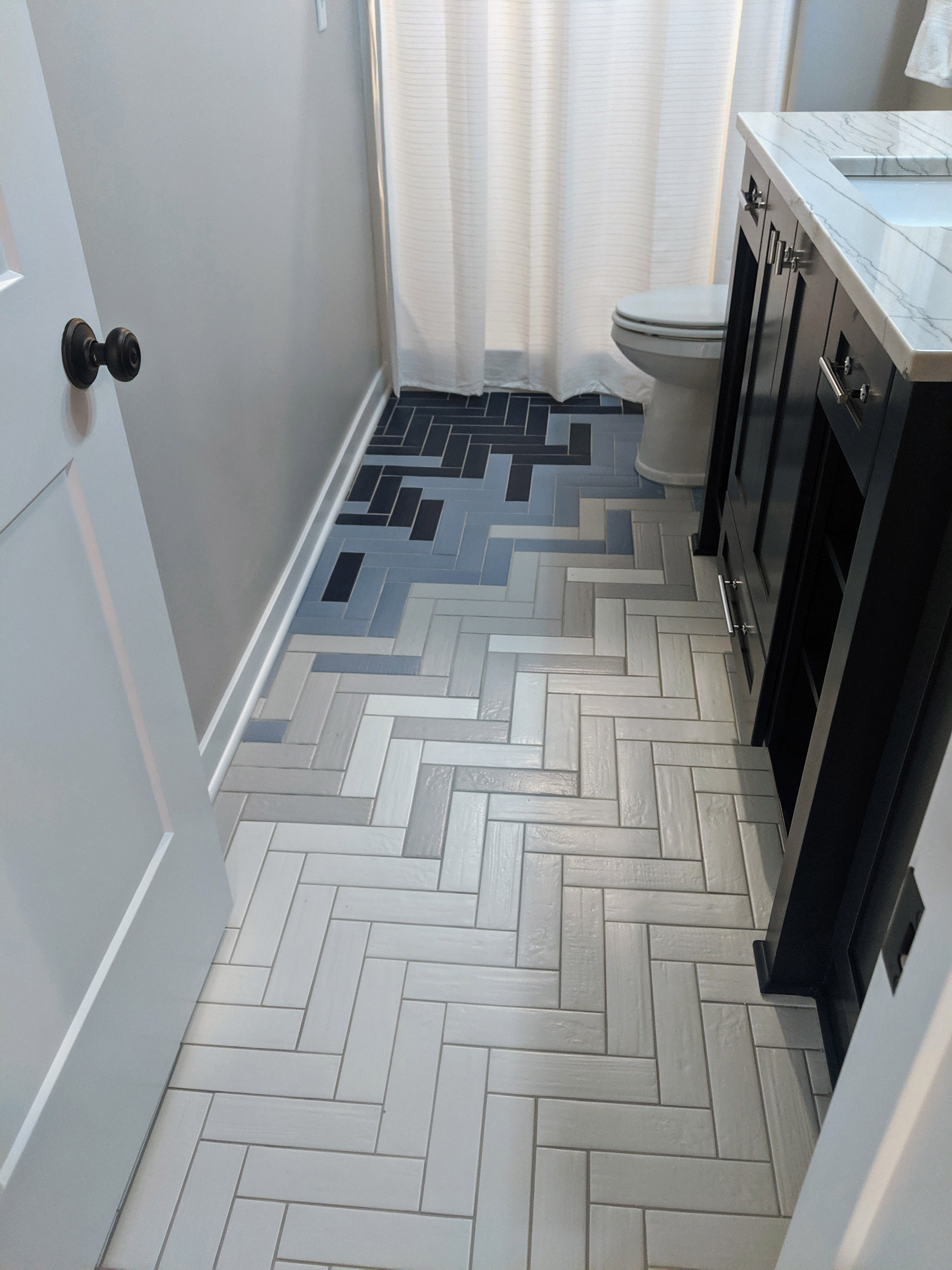 Herringbone tile pattern @ the ¾ bath with bleeding transfer of 4-colored tiles, brings a unique style to an otherwise boring bathroom tile