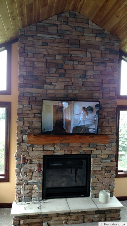  6' x 14' Stone fireplace w/ reclaimed timber mantle.